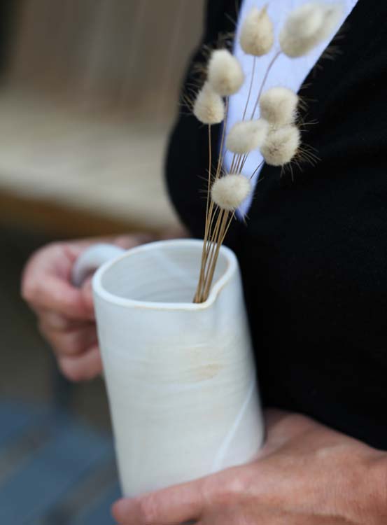 Agnes M, céramistes, qui tient un vase ou une cruche de sa création vers Paris
